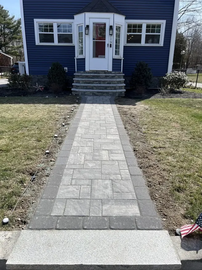 Straight paver walkway with a dark border leading to a front door