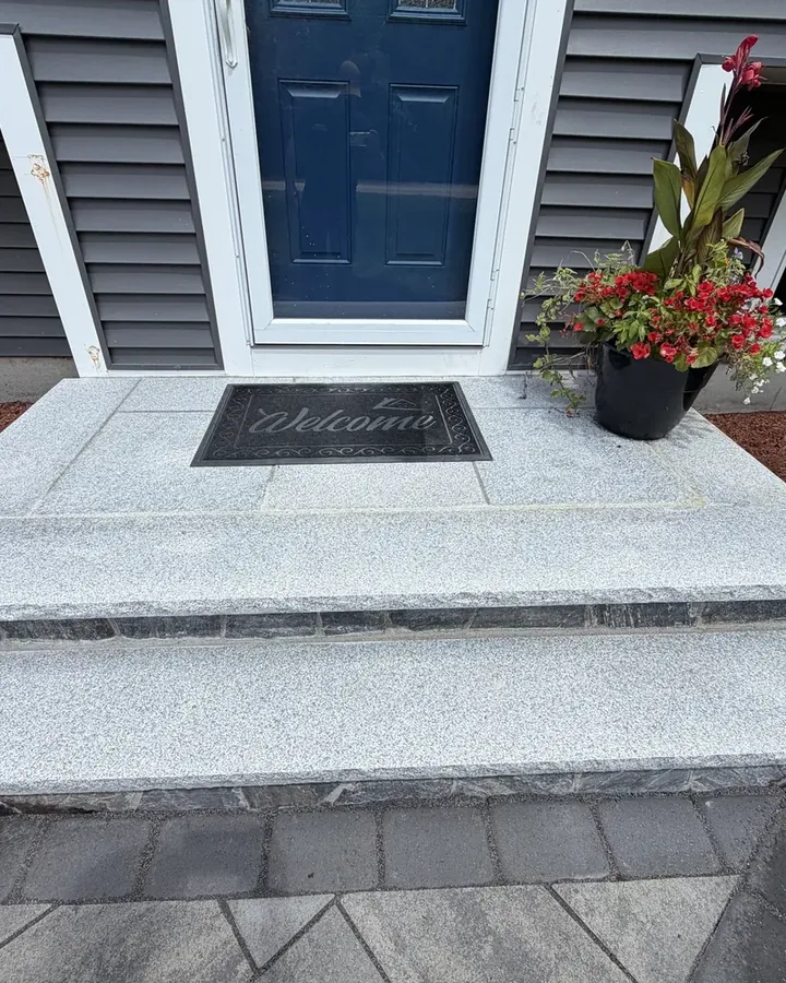 Granite front steps on a paver landing at the entrance of a house