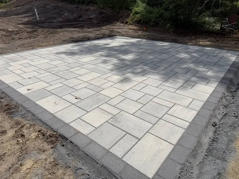 Newly installed large format paver patio with a dark border
