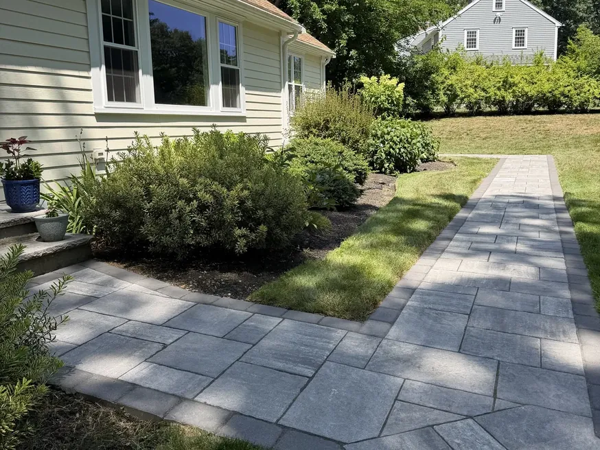 Gray paver walkway leading from the street to the front entry of a house